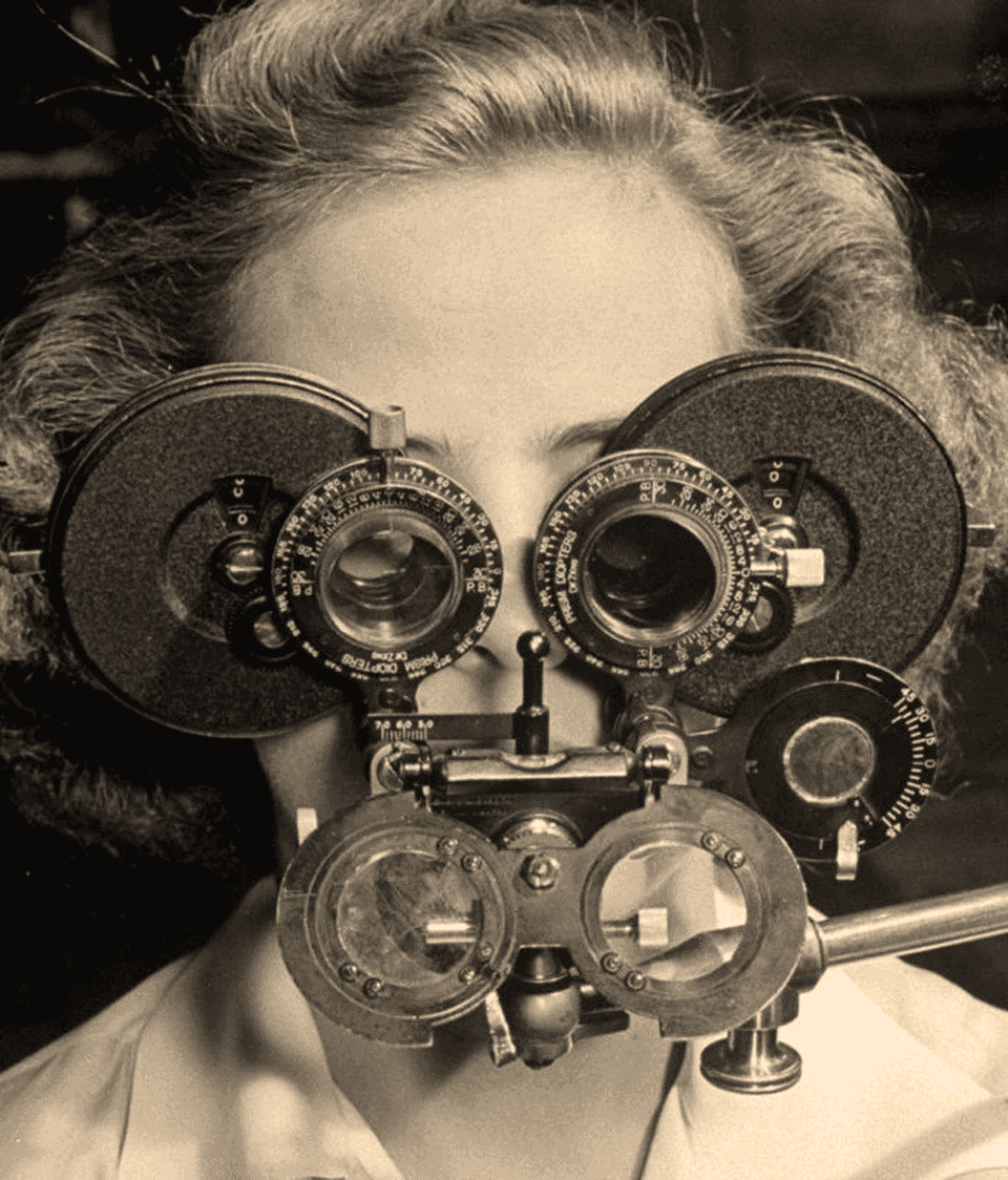 Vintage photo of a woman looking through a phoropter